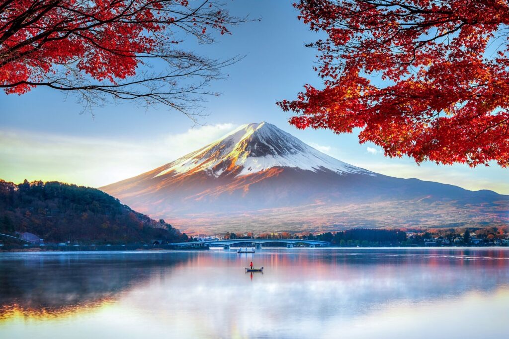 Mount Fuji behind autumn maple leaves and a calm lake